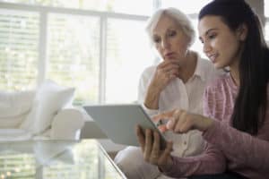 Grandmother and granddaughter using digital tablet living room Grandmother and granddaughter using digital tablet living room
