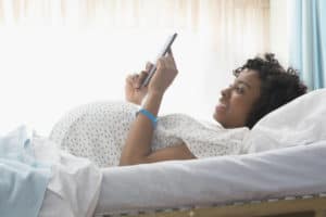 Pregnant African American woman using digital tablet in hospital Pregnant African American woman using digital tablet in hospital
