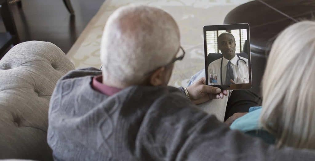Older man video chatting with digital tablet