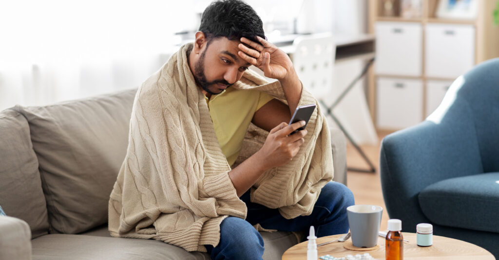 sick male using cell phone