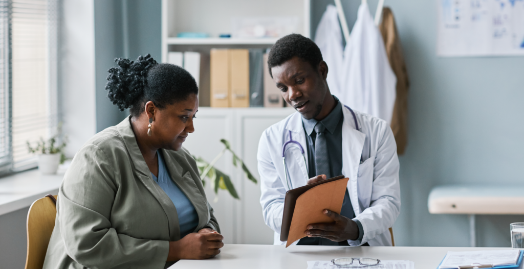 Black doctor going over instructions with a black female patient