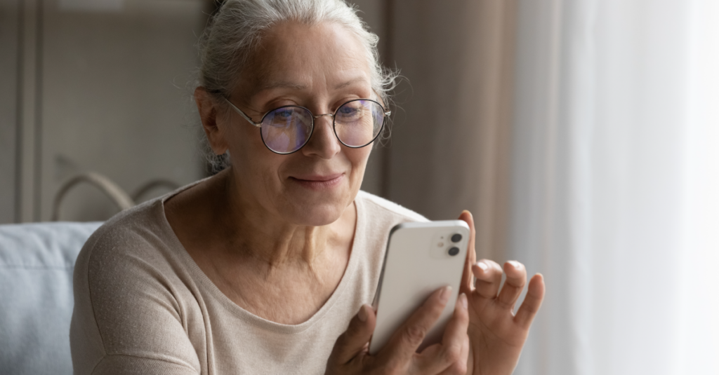 Woman with white hair looking at her cell phone